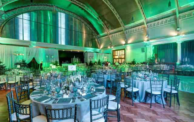 Gala event at Lindley Hall featuring round seating and green architectural uplighting.