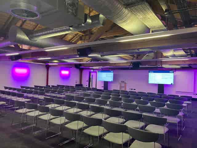Studio One + Two theater-style meeting room with purple lighting for corporate events and seminars.