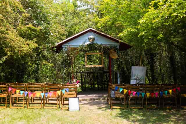Bohemian garden wedding ceremony with rustic wooden chairs and floral altar for intimate events.