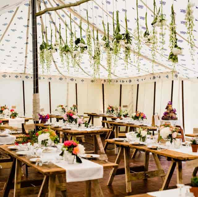 Bohemian tipi marquee with floral decor for rustic-chic weddings and garden events.