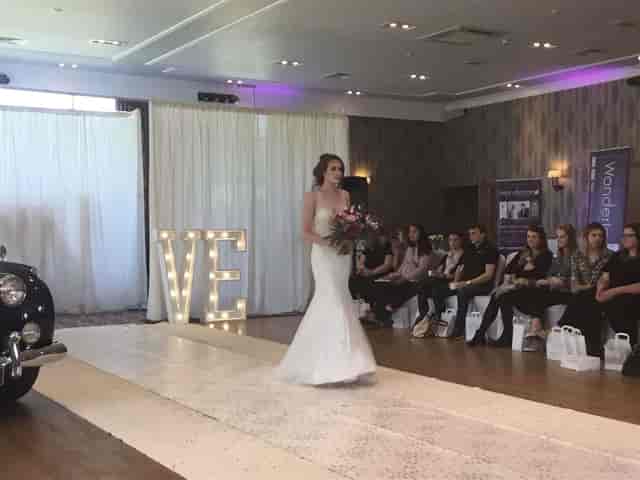 Drumossie Hotel ballroom bridal showcase with runway and theatrical backdrop for wedding events.