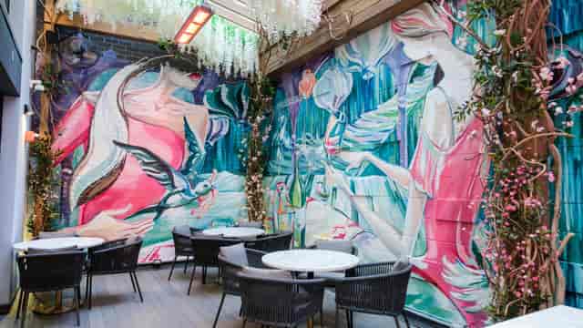 Boudoir at Brewhemia patio with floral mural, perfect for social mixers and VIP events.