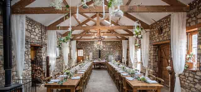Rustic-chic wedding venue at The Barn, Old Down Estate, featuring floral installations and seating.