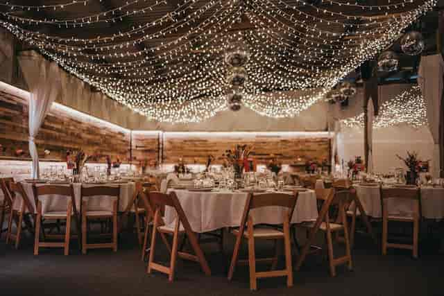Rustic Big Party Barn wedding venue with fairy lights and elegant ceiling draping.