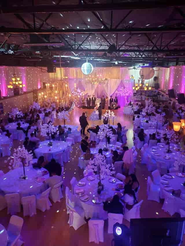 The Voodoo Rooms ballroom set for a formal event with stage, floral centerpieces, and uplighting.