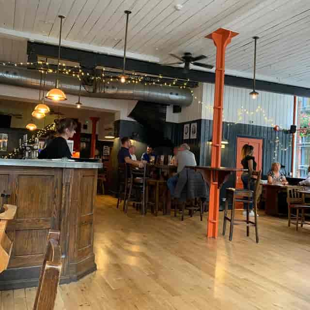 Industrial-chic networking venue with high-top seating for corporate mixers and social events.