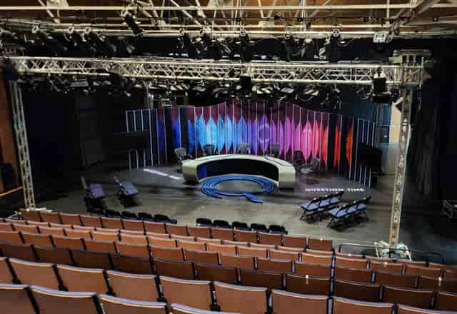 Stantonbury Theatre studio with panel desk and stage lighting for hybrid events and talk shows.