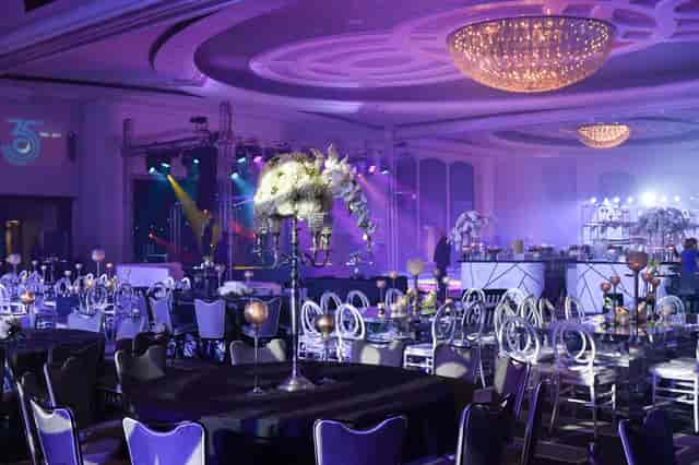Americana Ballroom gala with purple lighting and floral centerpieces for luxury event venues.