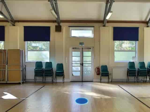 Main Parish Hall with stacked chairs for community events and workshops.