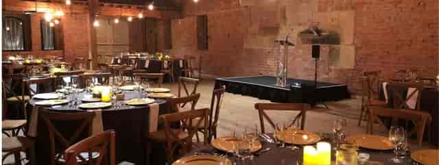 Revolution Manchester Gallery banquet setup: industrial event space with stage for gala or seminar.