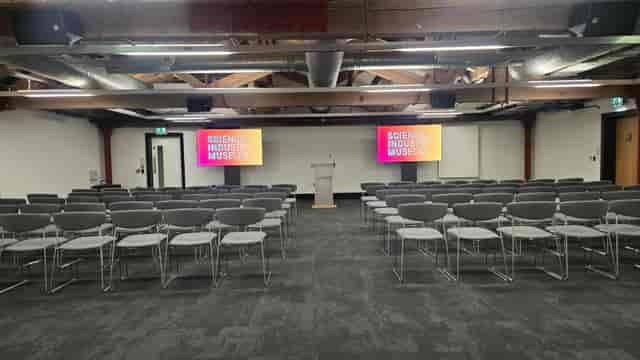 Atom Room One theater-style conference space for corporate presentations and panel discussions.