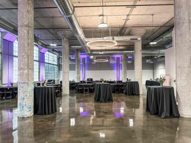 Industrial-chic Main Hall at The Loom with uplighting for corporate and social events.