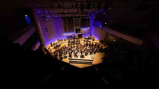 Orchestral performance at RNCM Theatre, tiered auditorium for plenary keynote events.
