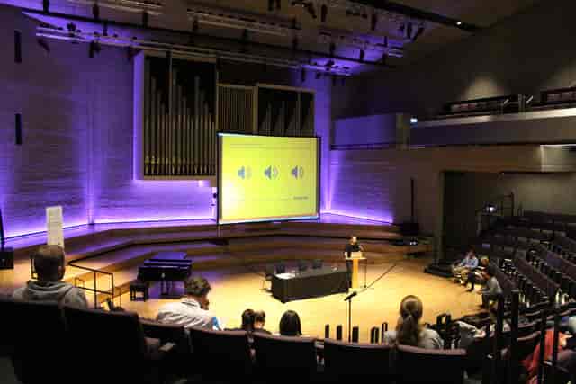 RNCM Theatre concert hall with purple lighting for lecture and presentation event.