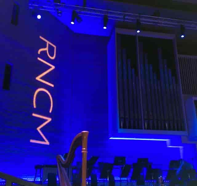 RNCM Theatre stage with blue LED lighting and pipe organ backdrop for corporate events.