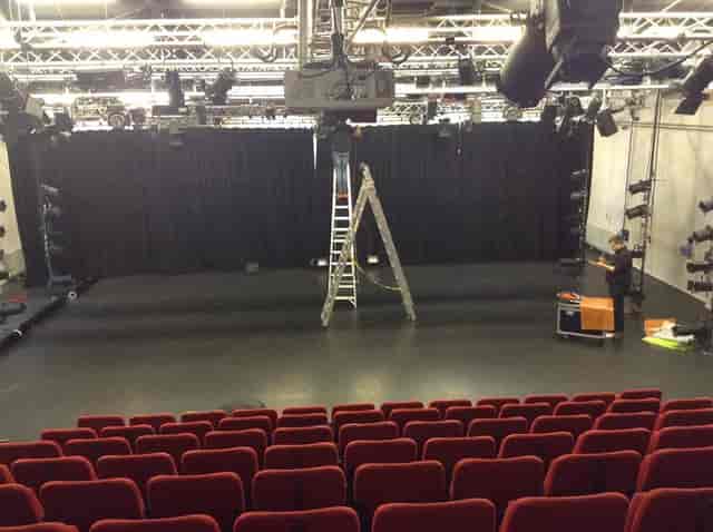 Technician prepping The ShowRoom theater for event production, staging and seating setup.