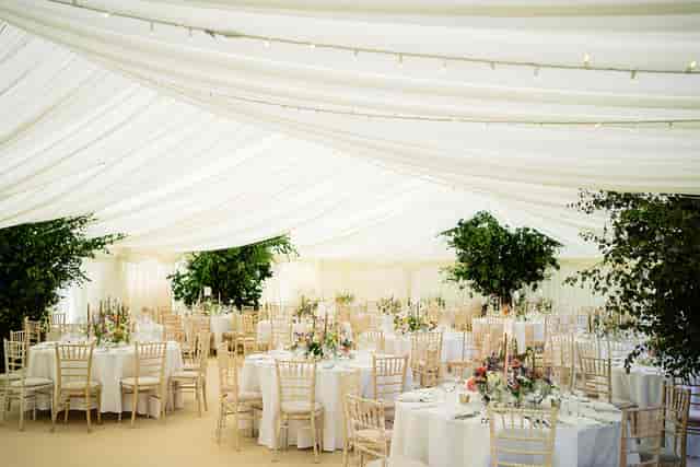 Lancing College marquee dining hall with elegant draping and greenery for weddings or corporate events.
