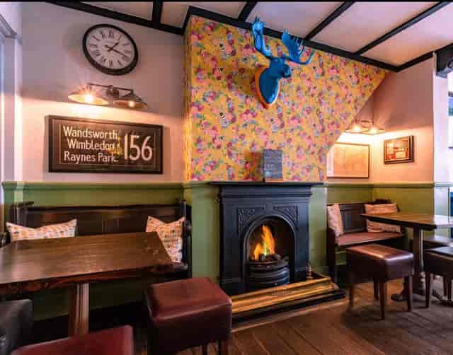 Cozy fireplace seating at The Beehive Clapham, ideal for private events and team drinks.