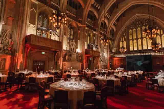 Gala event setup in historic Great Hall with dramatic lighting for premium awards dinner.