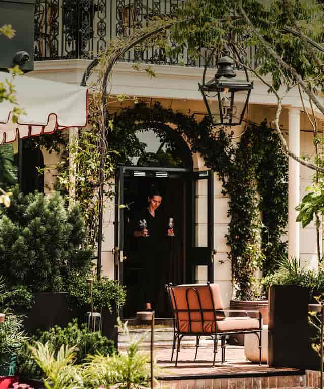 Luxe covered balcony venue with vine-clad walls for elegant outdoor events and private parties.