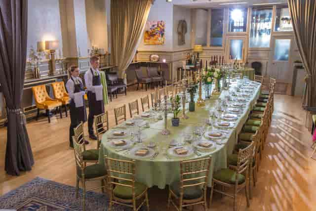 Boardroom-style wedding reception at The Embassy, London featuring elegant gold Chiavari chairs.