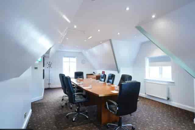 Surrey Room boardroom at The Hickstead Hotel: intimate sloped-ceiling space for executive meetings.