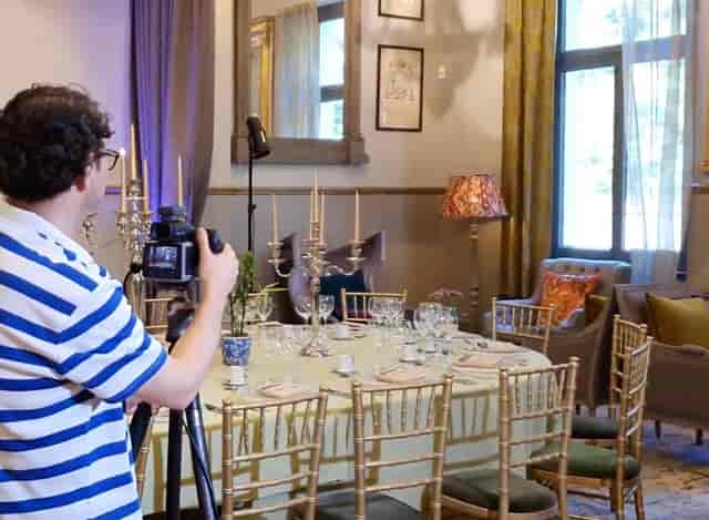 Videographer filming upscale dining table for luxury hospitality event content.