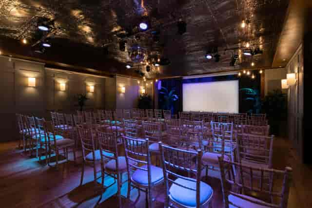 Storey Club Paddington event hall: theater-style corporate presentation space with moody lighting.