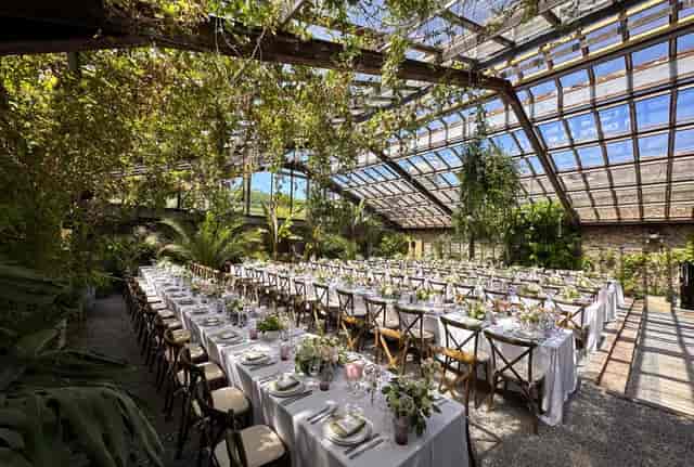 Private greenhouse restaurant with white linens for upscale weddings and corporate events.