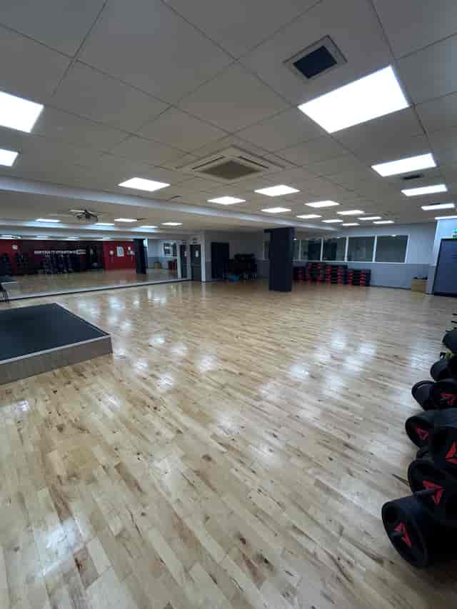 Studio with mirror walls and stage for fitness events and team-building workshops.