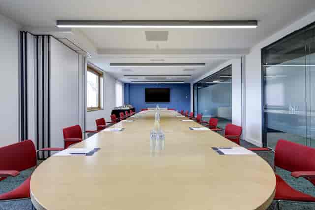 Boardroom at 10 Union Street featuring a wood table and red chairs for business meetings.