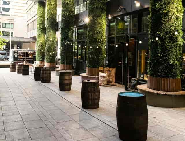 Outdoor terrace with barrel tables and string lighting for networking and casual corporate events.