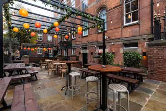 Industrial-chic outdoor breakout space with festoon lighting for networking and receptions.
