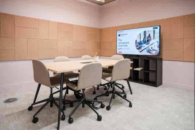 Tech-enabled huddle room with ergonomic seating for team collaboration and business meetings.