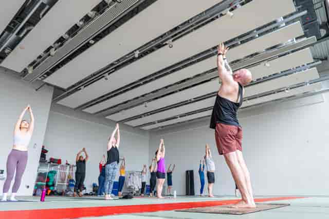 Moseley Sports Centre gymnasium hosting a corporate wellness event with high ceilings.