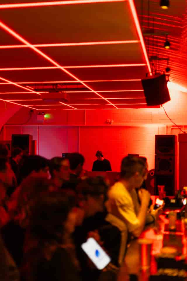 DJ at Bird House Brewery Arch 2, featuring bold red lighting for a warehouse dance event.