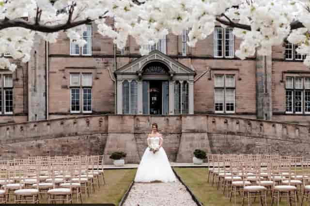 Outdoor wedding ceremony at Powfoulis Manor Hotel with floral decor and historic backdrop.