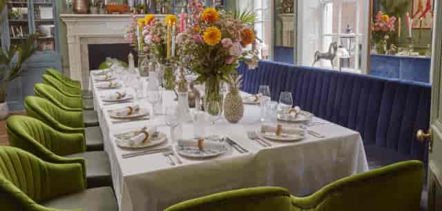 Private dining room with velvet seating and floral decor for corporate and social events.