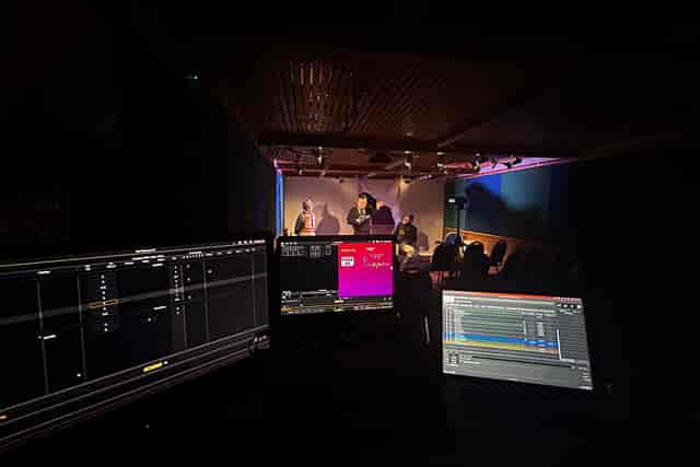 Live broadcast production at Chequer Mead Theatre with AV technicians and stage lighting.