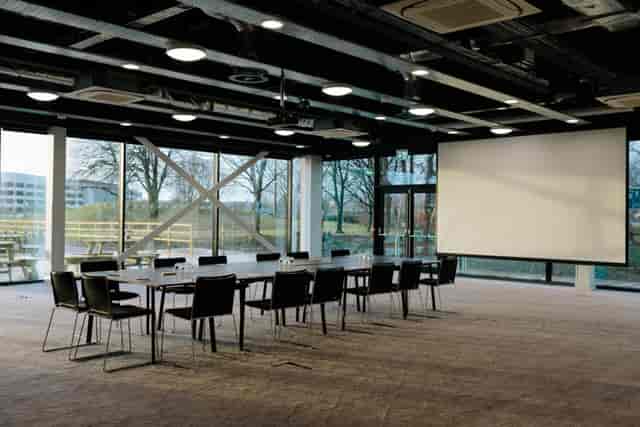 Industrial 8-person boardroom with natural light for corporate meetings and team collaboration.