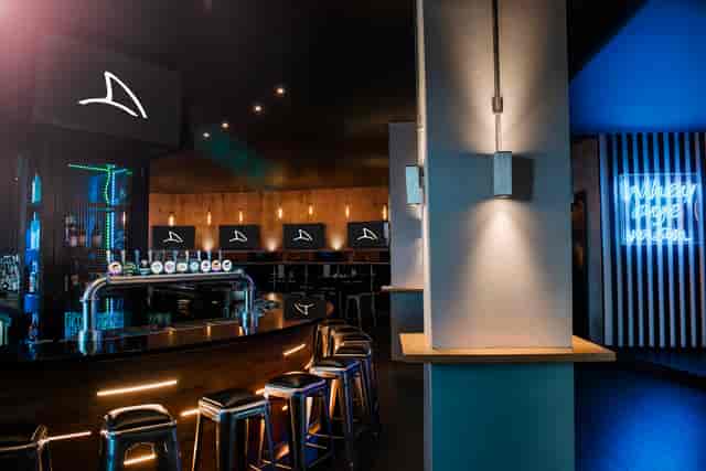 Semi-private bar lounge with moody lighting for networking events and corporate mixers.