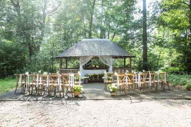 Garden Suite outdoor wedding ceremony with gazebo and cross-back chairs.