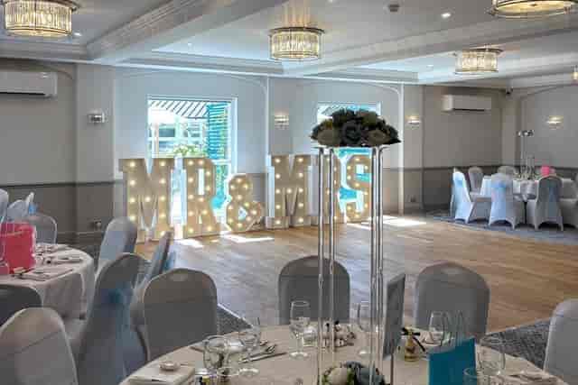 Wedding reception at Four Ashes Regency Hotel with marquee lights and tall glass centerpieces.