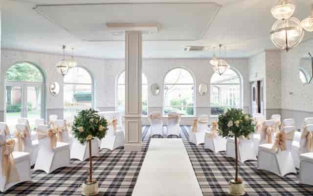 Regency Hotel Solihull wedding ceremony in high-ceilinged room with signature plaid carpet.