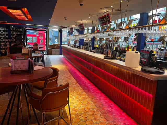 Modern LED-lit Main Bar at Revolution America Square for networking events and wrap parties.