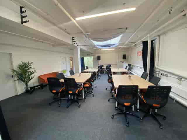 Industrial breakout space with modular tables for collaborative workshops and team meetings.