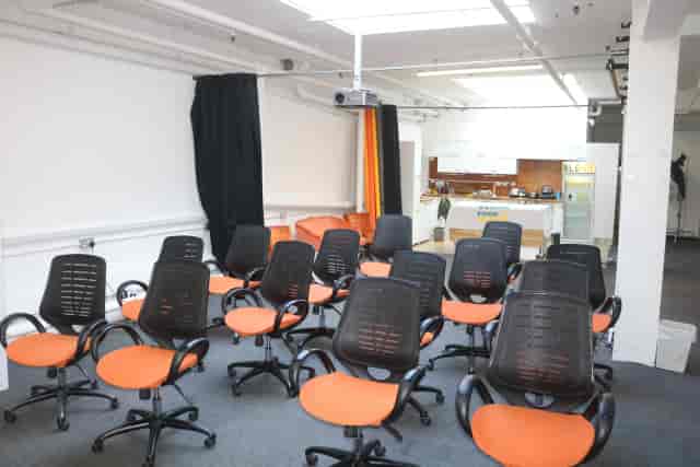 Bright orange seating in informal Canvas Studios breakout space for creative workshops and meetings.