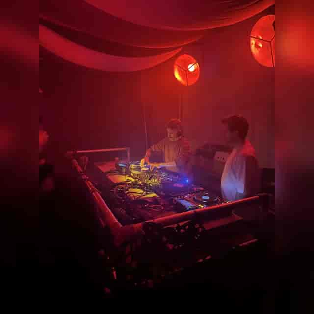 DJ setup in aesthetic creative space with red lighting for nightclub event venue.