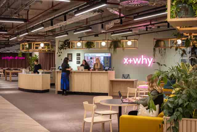 Contemporary biophilic coworking space with lounge seating for hybrid events and networking.