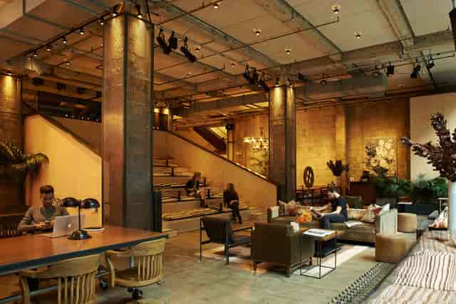 Industrial-chic co-working space with tiered seating for corporate meetings and workshops.